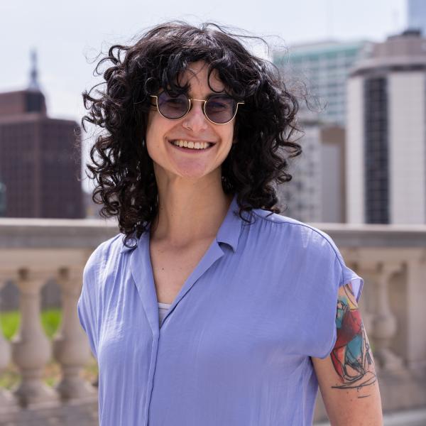 Girl with black curly hair and blue button down